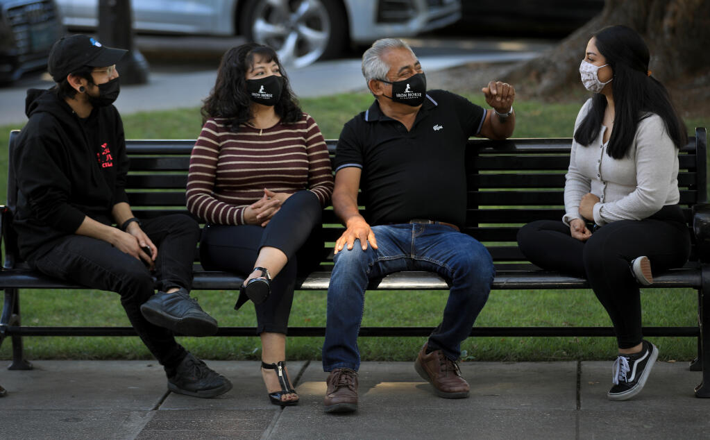 From left, Victor, Maria, Victor Sr., and Michelle Arreola all had COVID last summer and are taking no chances even after being fully vaccinated.  Just recently they've been getting out around Healdsburg and relaxing at the plaza, Friday, March 26, 2021. (Kent Porter / The Press Democrat) 2021