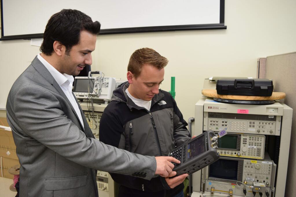 Sonoma State University engineering professor Haider Khaleel advises student Jon Porrazzo on his project, a smoke detector that alerts a smartphone.