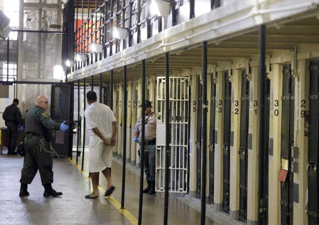 In this Aug. 16, 2016 photo, an inmate is led out of his cell at San Quentin State Prison in San Quentin, Calif. Lawmakers, criminal law scholars and former federal and state judges appointed to the state Committee on Revision of the Penal Code by Gov. Gavin Newsom and legislative leaders are closely examining California’s incarceration rates and plan to make policy recommendations to lower them. (AP Photo/Eric Risberg, File)