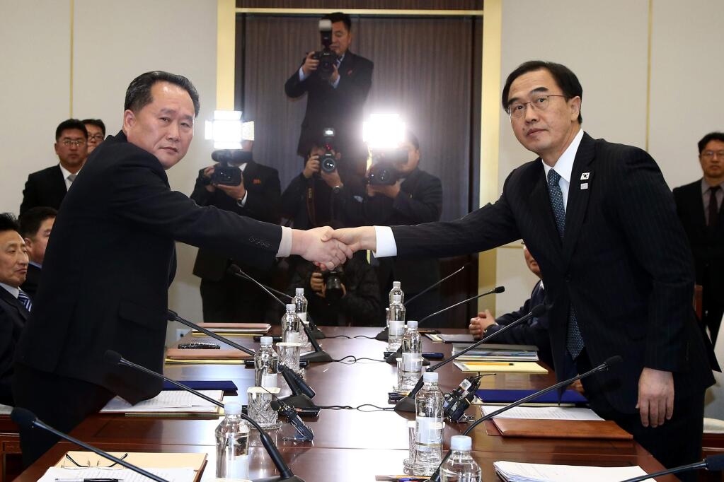 South Korean Unification Minister Cho Myoung-gyon, right, shakes hands with the head of North Korean delegation Ri Son Gwon during their meeting at the Panmunjom in the Demilitarized Zone in Paju, South Korea, Tuesday, Jan. 9, 2018. The rival Koreas took steps toward reducing their bitter animosity during rare talks Tuesday, as North Korea agreed to send a delegation to next month's Winter Olympics in South Korea and reopen a military hotline. (Korea Pool via AP)