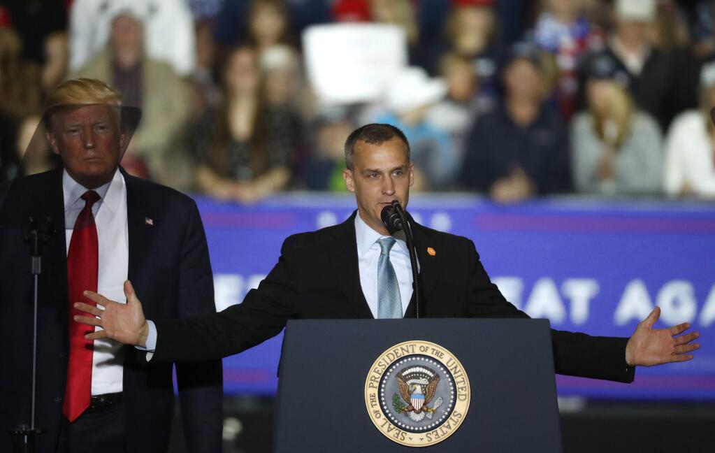 FILE - In this April 28, 2018 file photo, President Donald Trump, left, watches as Corey Lewandowski, right, his former campaign manager for Trump's presidential campaign, speaks during a campaign rally in Washington Township, Mich. Lewandowski has created a stir by dismissing a story about a girl with Down syndrome with a sarcastic 'Wah wah.' Lewandowski appeared Tuesday, June 19, 2018, on Fox News Channel to discuss the president's hard-line immigration policy, which has led to the practice of taking migrant children from parents charged with entering the country illegally. (AP Photo/Paul Sancya, File)