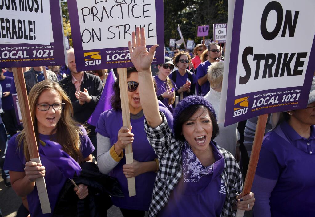 (From right) Alicia Tuso, Juana Marquez, and Teresa Baldassari attend a rally with members of the Service Employees Union Local 1021 outside the Sonoma County Administration Building in Santa Rosa, on Tuesday, November 17, 2015. (BETH SCHLANKER/ The Press Democrat)