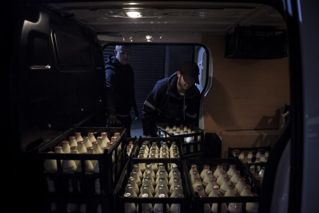 A driver loads a Modern Milkman van in Stockport, in northwest England, March 25, 2020. The milk-delivery industry, which symbolized the distant past, has taken off as people self-isolate and order their shopping from home in the aftermath of the coronavirus pandemic. (Mary Turner/The New York Times)