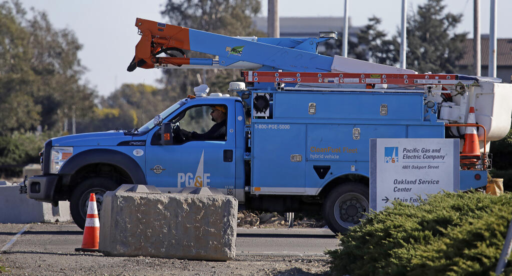 FILE - In this Feb. 11, 2020, file photo, a Pacific Gas & Electric truck leaves the company's Oakland Service Center in Oakland, Calif.  (AP Photo/Ben Margot, File)