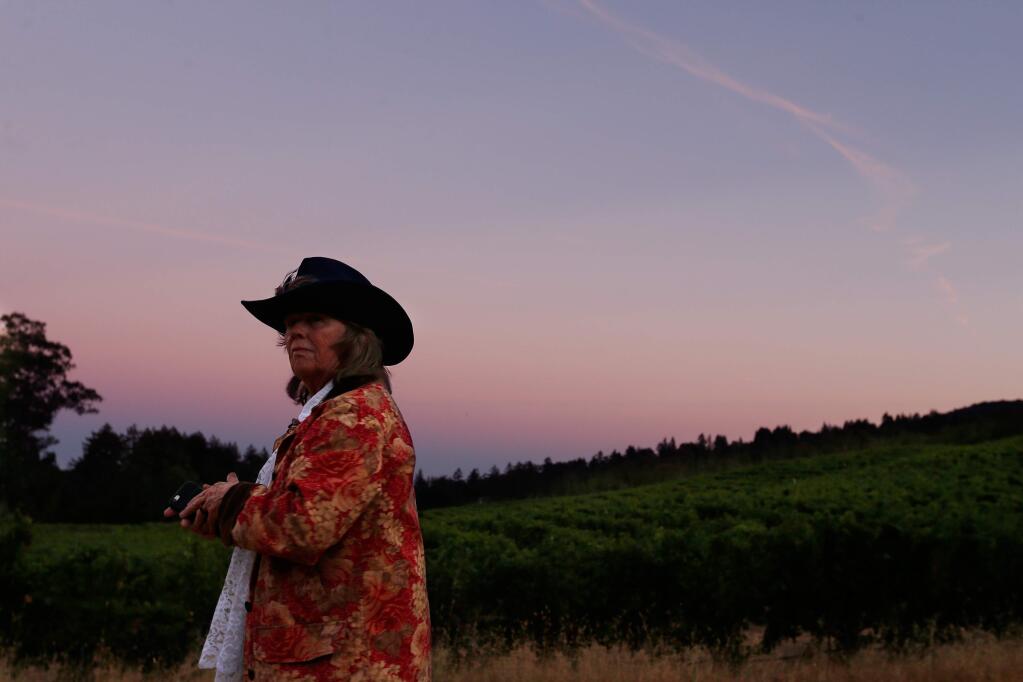Carolyn Greene takes a moment to enjoy the sunset view of the vineyards during Call of the Wild, a Jack London celebration and benefit for Jack London State Historic Park, in Glen Ellen, California on Saturday, September 17, 2016. (Alvin Jornada / The Press Democrat)