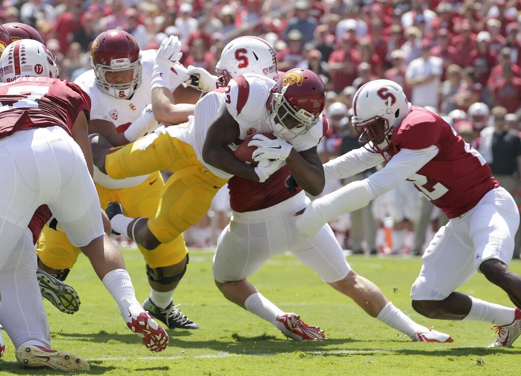 Southern California running back Justin Davis dives in for a touchdown past Stanford safety Kyle Olugbode (22) during the first half of an NCAA college football game on Saturday, Sept. 6, 2014, in Stanford, Calif. (AP Photo/Tony Avelar)