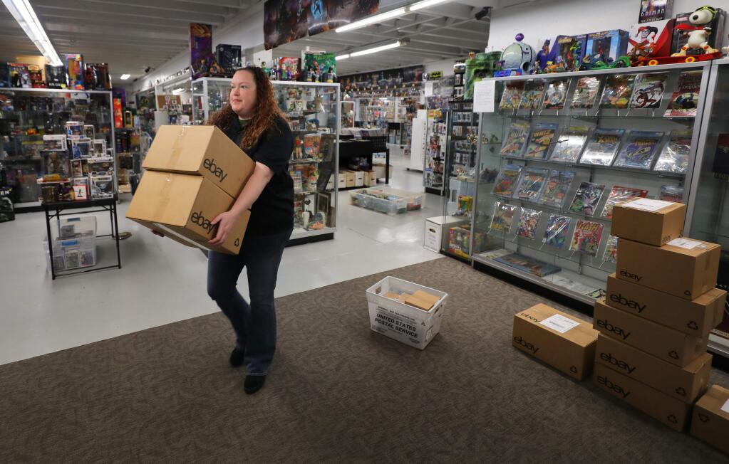 Amanda Barlow prepares online orders for shipment pickup at the Batcave Comics & Toys store in Santa Rosa on Wednesday, March 25, 2020. Co-owners Barlow and Mike Holbrook putting more merchandise for sale online to survive the closure of their Railroad Square store during the coronavirus shutdown.(Christopher Chung/ The Press Democrat)