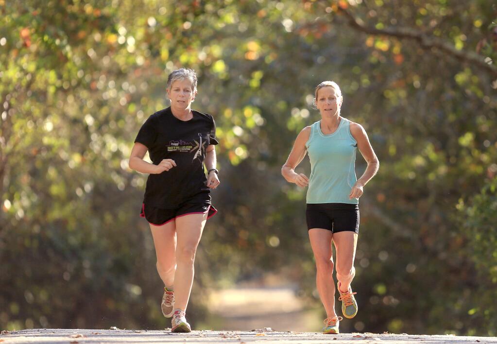 Ann DuBay, left, and sister Catherine DuBay run along a trail at Howarth Park.