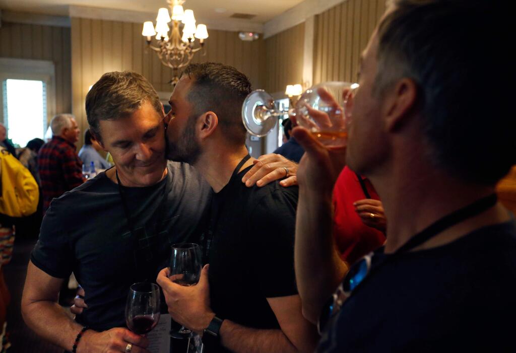 Orlando resident Steve Yacovelli, center, kisses his husband Richard Egan as they talk with friends about the Pulse night club shooting, at a reception during Gay Wine Weekend in Sonoma, California on Friday, June 17, 2016. (Alvin Jornada / The Press Democrat)