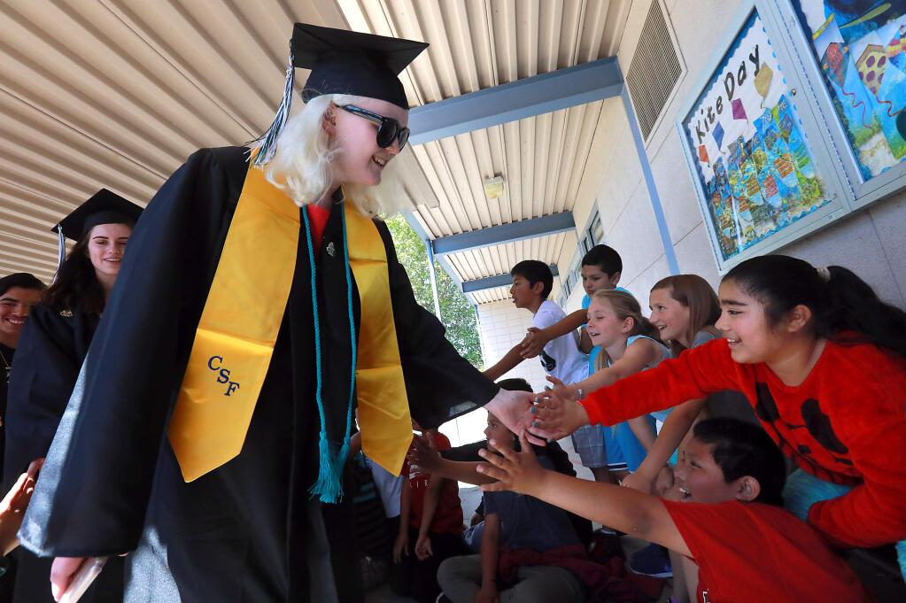 Sonoma Valley High School senior Theadora Bridant, 18, donned her cap and gown early to inspire students at her former elementary school, Sassarini Elementary School in Sonoma, during a Senior Walkabout. (John Burgess/The Press Democrat)