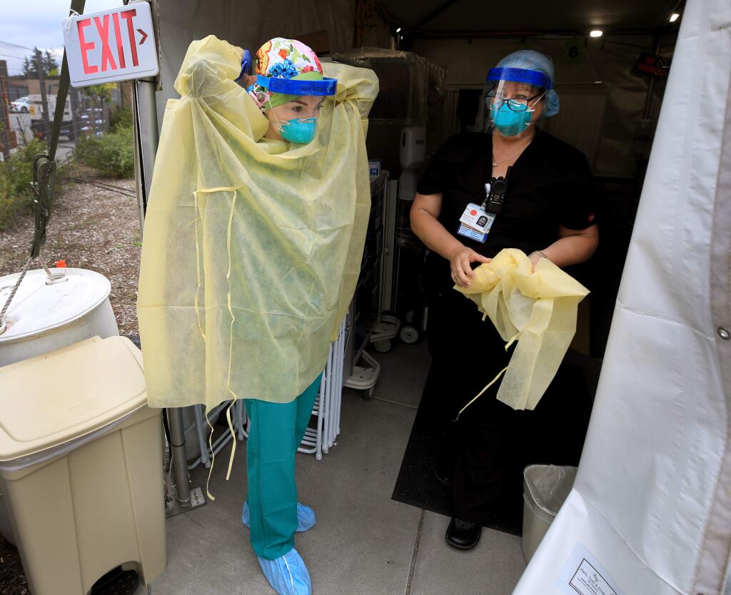 Outside one of two coronavirus surge tents at Sutter Santa Rosa Regional Hospital, RN Sophia Walter, prepares to give RN Jeannie Langridge a scheduled break, Friday, April 17, 2020. (Kent Porter / The Press Democrat) 2020