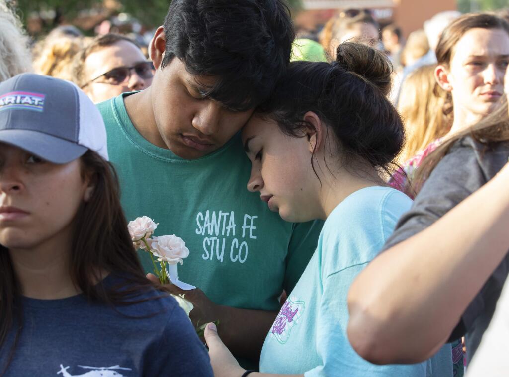 People embrace during a prayer vigil following a shooting at Santa Fe High School in Santa Fe, Texas, on Friday, May 18, 2018. Seventeen-year-old Dimitrios Pagourtzis is charged with capital murder in the deadly shooting rampage. (Stuart Villanueva The Galveston County Daily News via AP)