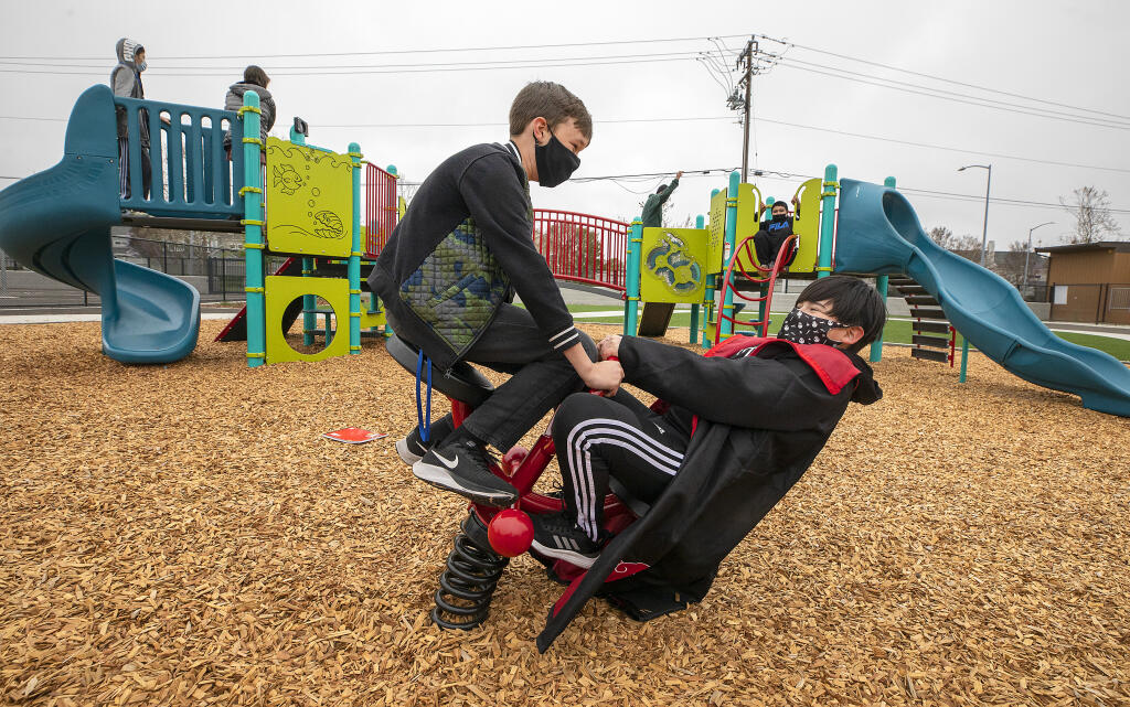 Students have fun on the new playground equipment during recess at the Spanish-English dual language immersion program Cesar Chavez Language Academy on Tuesday, April 6, 2021.  (Photo by John Burgess/The Press Democrat)