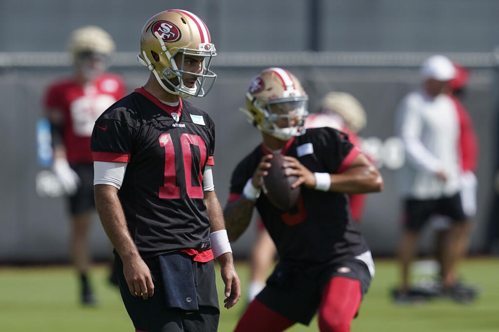 FILE - San Francisco 49ers quarterbacks Jimmy Garoppolo, left, and Trey Lance are shown at NFL football training camp in Santa Clara, Calif., Thursday, July 29, 2021. The 49ers report to training camp with intrigue about what the team plans to do with former starting quarterback Jimmy Garoppolo with Trey Lance set to take his place.(AP Photo/Jeff Chiu, File)