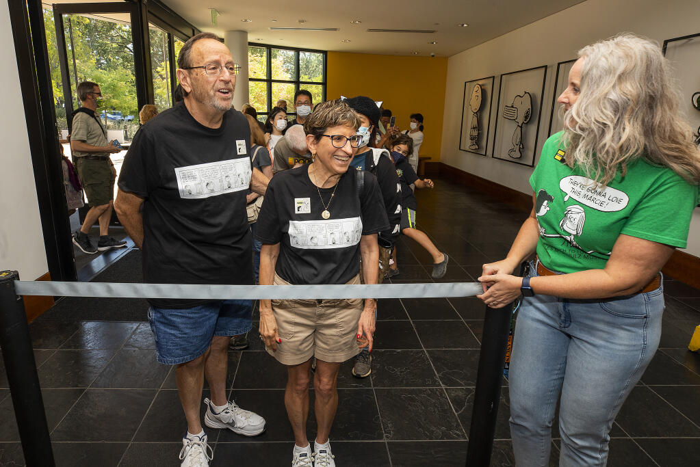 Rosemary Giacomini, right, greets Ken And Laney Gutstein, of Henderson, NV, who were the first in line when The Charles M. Schulz Museum and Research Center first opened in 2002 and were the first to enter the museum on the 20th anniversary Monday, August 15, 2022. (John Burgess/The Press Democrat)