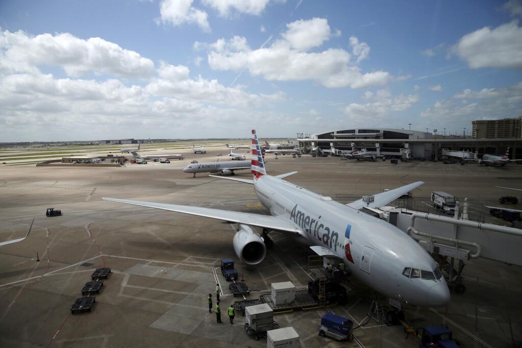 In this June 16, 2018 photo, American Airlines aircrafts are seen at Dallas-Fort Worth International Airport in Grapevine, Texas. American Airlines says it asked the Trump administration not to put migrant children who have been separated from their parents on its flights. In a statement Wednesday, June 20, American said it doesn't know whether any migrant children have been on its flights and doesn't want to profit from the current immigration policy of separating families. (AP Photo/Kiichiro Sato)