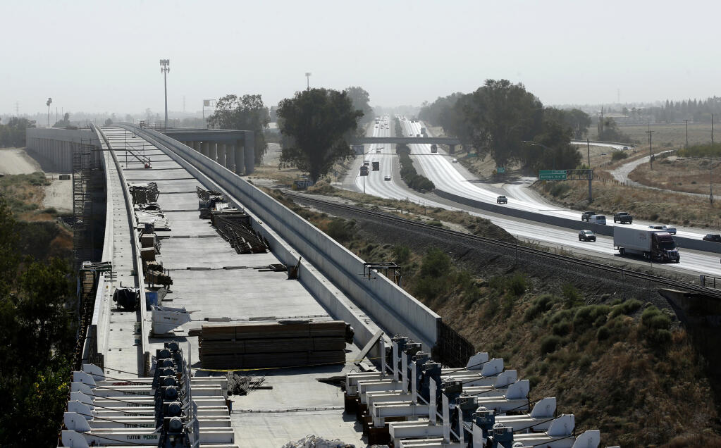 FILE - In this Oct. 9, 2019, file photo, is the high-speed rail viaduct paralleling Highway 99 near Fresno, Calif. The federal government has reached an agreement to restore nearly $1 billion in funding for California's troubled bullet train. Gov. Gavin Newsom announced Thursday night, June 10, 2021, that the U.S. Department of Transportation finalized settlement negotiations to restore money for the high-speed rail project that the Trump administration revoked in 2019. (AP Photo/Rich Pedroncelli, File)
