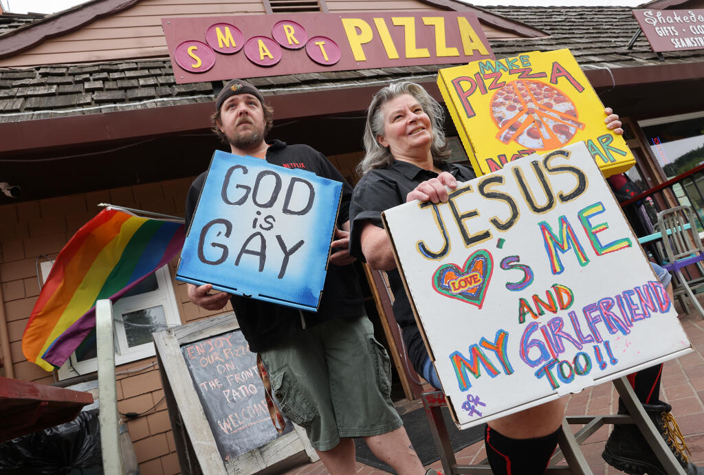 Smart Pizza owner Suzy Kuhr, aka "Duchess of Dough", right, and Louis Britton, aka "Paisano of Pies", faced off with anti-gay protestors earlier this year with their own messages written on pizza boxes in Guerneville.  (Christopher Chung/ The Press Democrat)