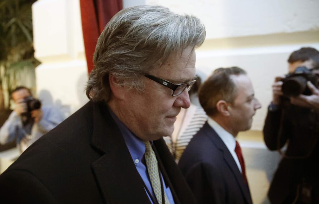FILE - In this March 23, 2017 file photo, White House chief strategist Steve Bannon, left, walks on Capitol Hill in Washington. President Donald Trump removed Bannon from the National Security Council, reversing an earlier controversial decision to give Bannon access to the high-level meetings. (AP Photo/Alex Brandon, File)