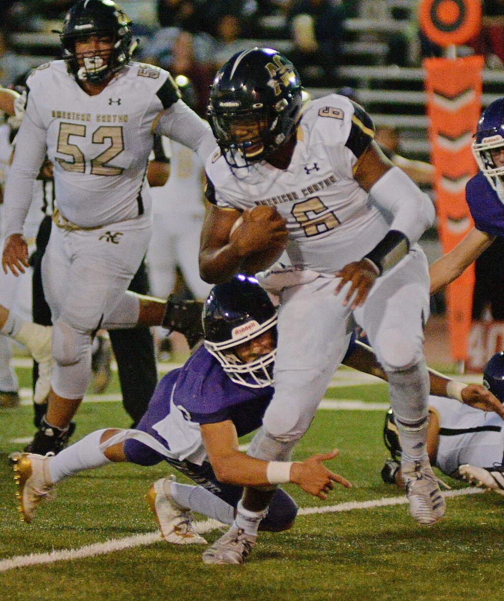 Petaluma's Jack Hartman makes an ankle tackle on American Canyon's 210-pound quarterback Vance Eshenburg in the the VVAL opening game won by American Canyon, 34-0. (Argus-Courier)