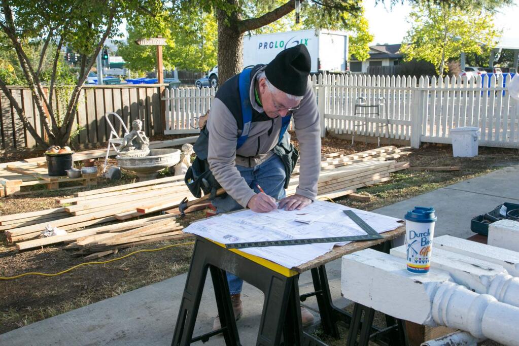 Richard Graalfs works out stairway calculations for rebuilding the front porch of Irma Castillo's home on Broadway. He was one of a small army of Habitat for Humanity volunteers working Tuesday, Oct. 15, 2016. (Photo by Julie Vader/Special to the Index-Tribune)