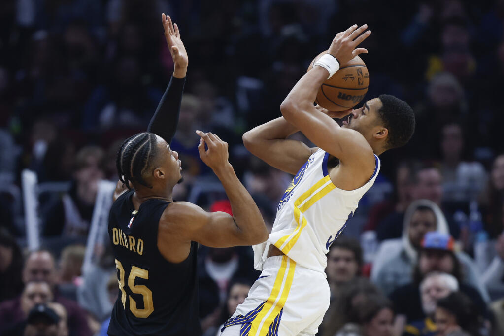 Warriors guard Jordan Poole shoots against Cavaliers forward Isaac Okoro during the first half Friday in Cleveland. (Ron Schwane / ASSOCIATED PRESS)