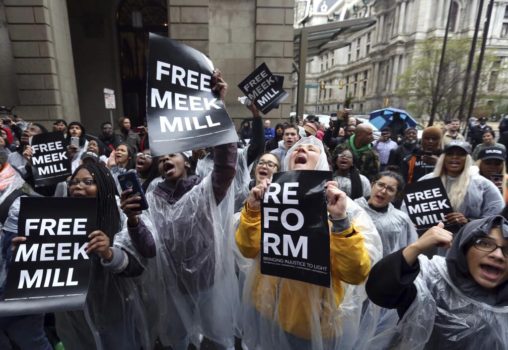 Protesters demonstrate in front of a courthouse during a hearing for rapper Meek Mill, Monday April 16, 2018 in Philadelphia. The city's district attorney says Mill's convictions should be vacated and he should have a new trial. The announcement came during a hearing on Monday, but a judge is still refusing to release Mill on bail. Philadelphia-born Mill was sentenced in November 2017 to two to four years in prison for violating probation on a roughly decade-old gun and drug case.(AP Photo/Jacqueline Larma)