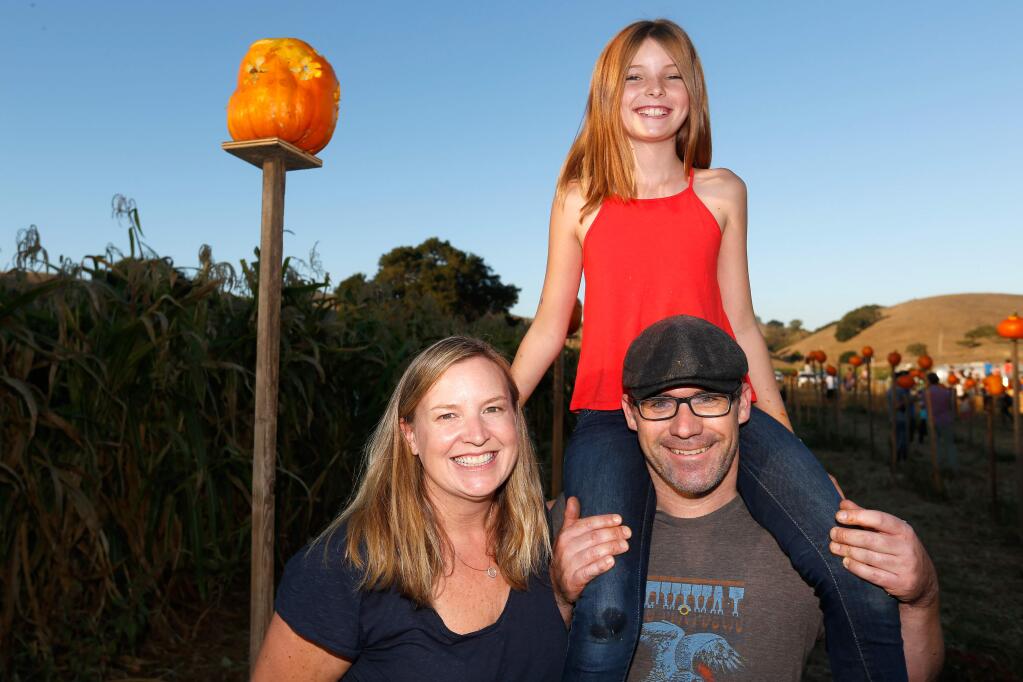 Kathy Lake, left, Jim Vazquez, and Stella Jay Lake, 10, attend Pumpkins on Pikes, a fundraising event which benefits the youth experience program at Tara Firma Farms in Petaluma, California, on Saturday, October 20, 2018. (Alvin Jornada / The Press Democrat)