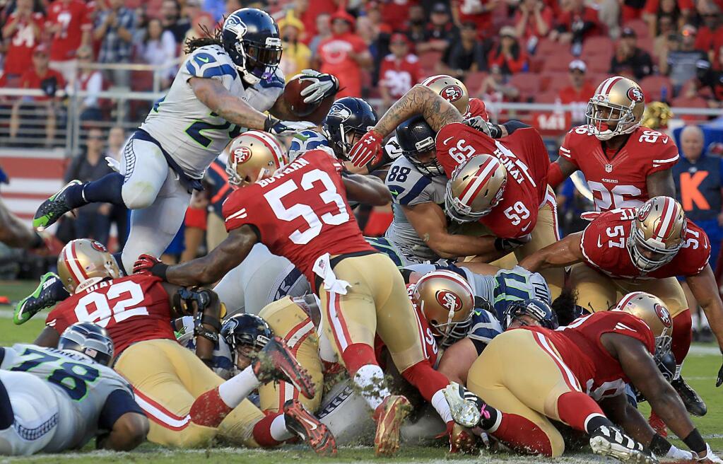 The Seattle Seahawks' Marshawn Lynch leaps a tangle of linemen, scoring from one yard out, in the first quarter against the 49ers during San Francisco's 20-3 loss at Levi's Stadium, Thursday Oct. 22, 2015. (Kent Porter / Press Democrat)
