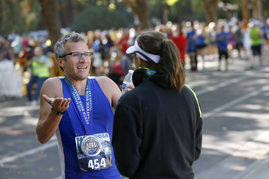 Abraham Sheppard tries to argue his case with Beth Carter, the pace team coordinator for the Santa Rosa Marathon, after he failed to qualify for the Boston Marathon because of an .9-mile detour accidentally taken by the pace-setter. Photo taken at the finish of the Santa Rosa Marathon at Juilliard Park on Sunday, August 28, 2016 in Santa Rosa, California . (BETH SCHLANKER/ The Press Democrat)