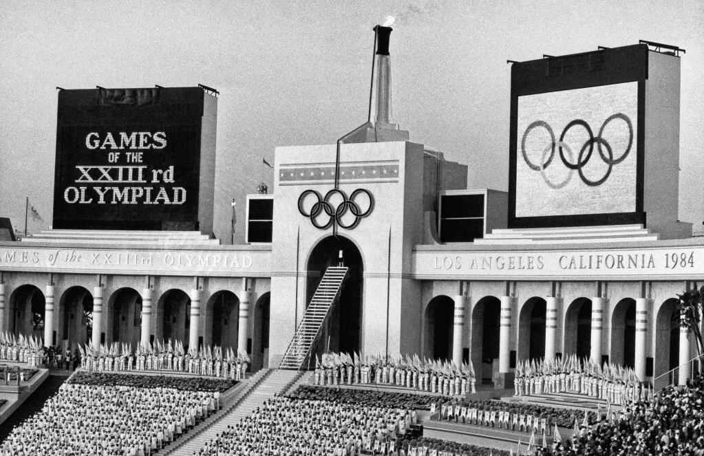 FILE - In this July 28, 1984 file photo, the Olympic flame is flanked by a scoreboard signifying the formal opening of the XXIII Olympiad after it was lit by Rafer Johnson during the opening ceremonies in the Los Angeles Memorial Coliseum. The U.S. Olympic Committee on Tuesday, Sept. 1, 2015, named Los Angeles as its candidate for the 2024 Games, replacing Boston's soured bid and marking a comeback for LA's dream of becoming a three-time host of the global sports competition. (AP Photo/Eric Risberg, File)