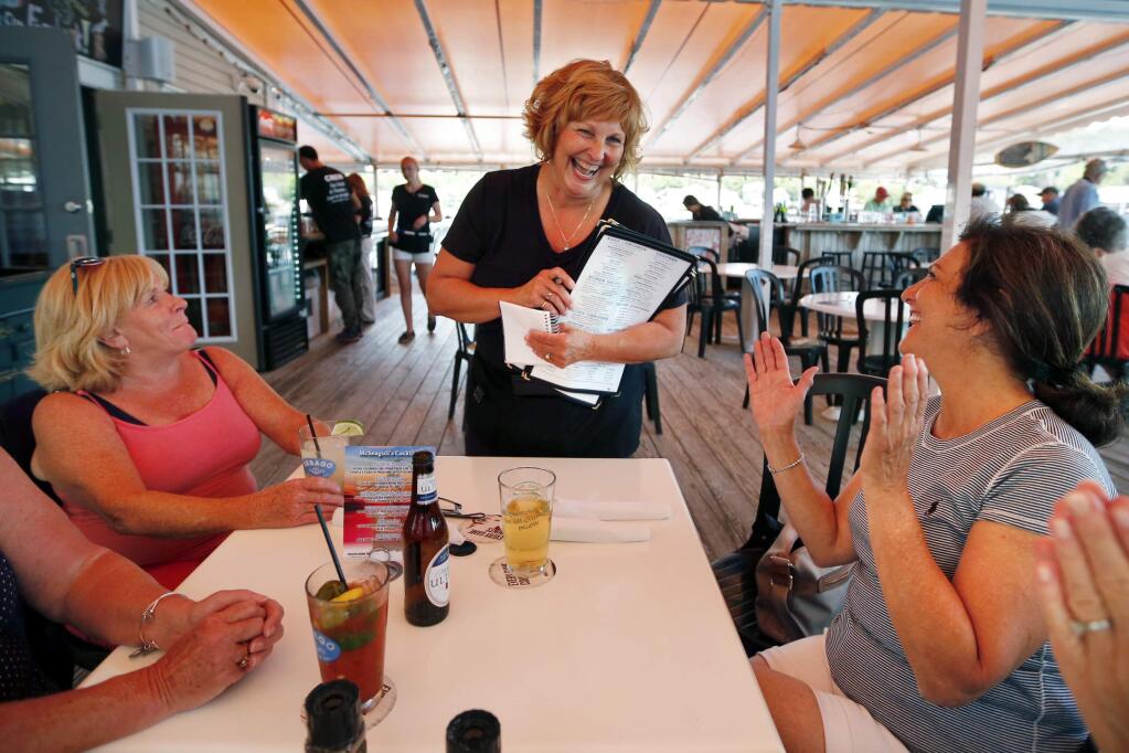 Ann LePage chats with diners after taking their order at McSeagull's restaurant, Thursday, June 23, 2016, in Boothbay Harbor. The wife of America's lowest paid governor has taken on a summer waitressing job near her and husband's Boothbay home, and she's saving up for a car. (AP Photo/Robert F. Bukaty)