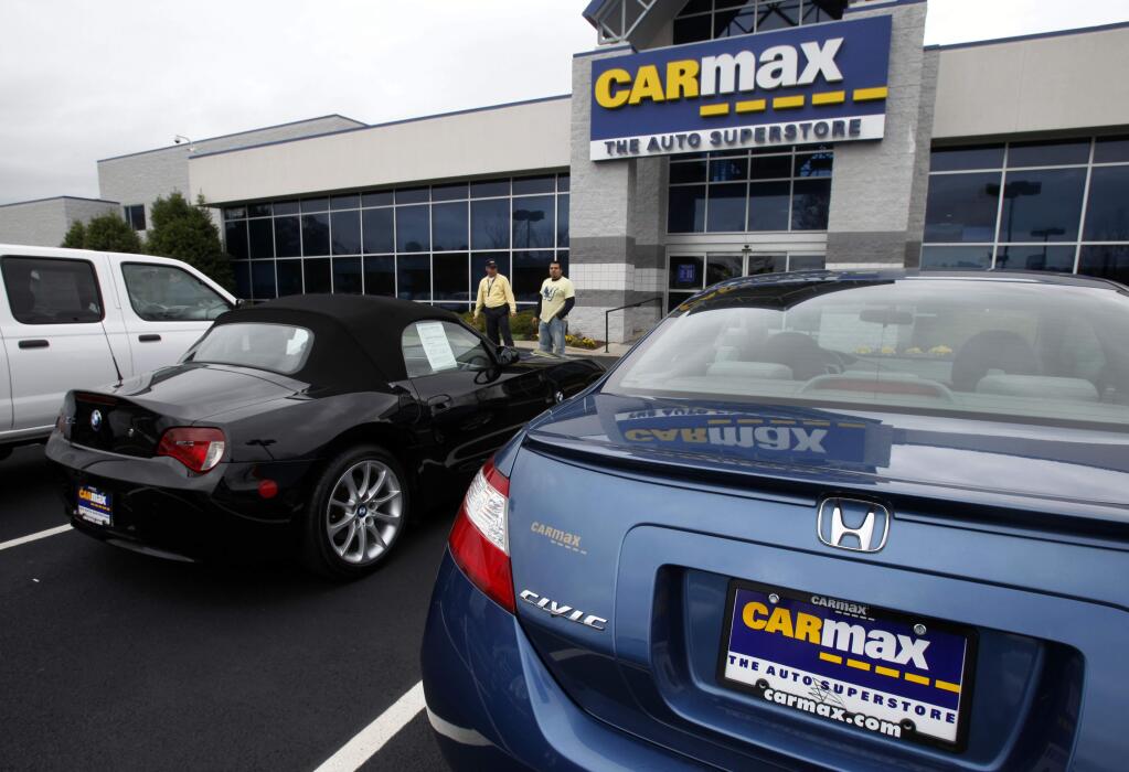 In this April 1, 2009 photo, a salesperson talks to a customer at a Carmax lot in Richmond, Va. (AP Photo/Steve Helber)