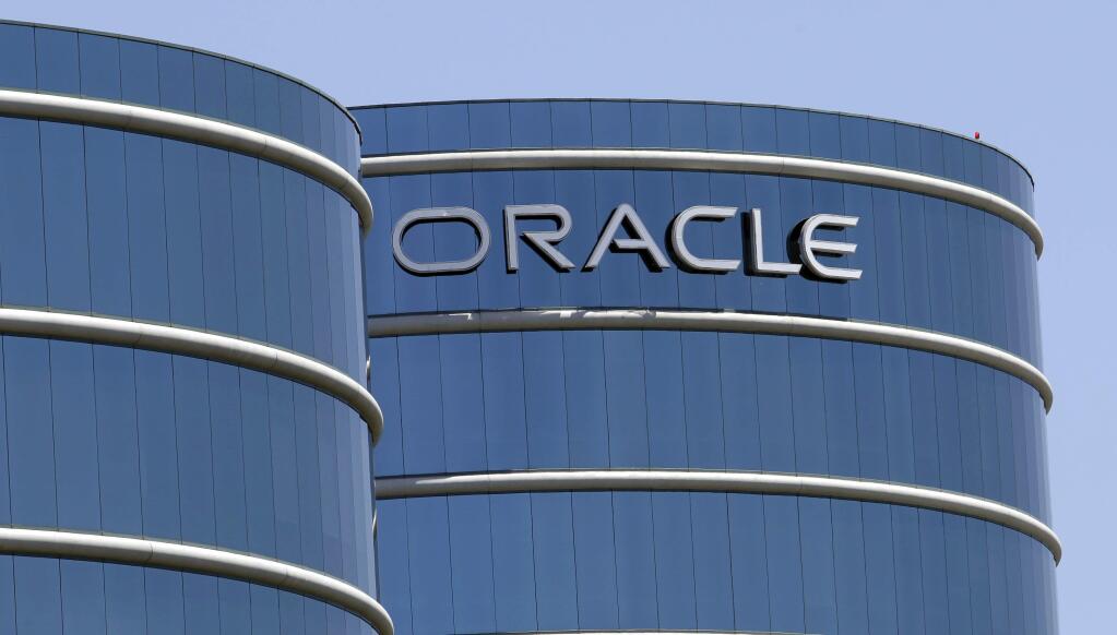 FILE - This June 18, 2012, file photo shows Oracle headquarters in Redwood City, Calif. The Labor Department is suing Oracle, claiming that the technology giant pays white male workers more than their non-white and female counterparts with the same job titles. In a statement issued Wednesday, Jan. 18, 2017, Oracle called the lawsuit 'politically motivated, based on false allegations and wholly without merit.' (AP Photo/Paul Sakuma, File)