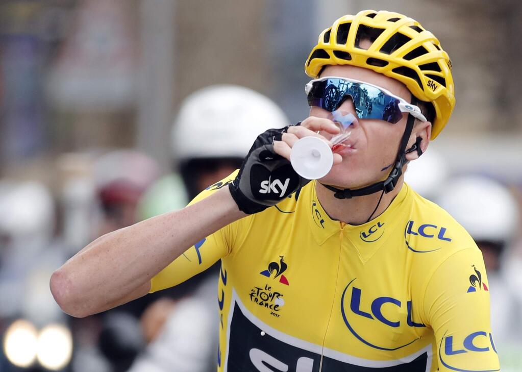 Britain's Chris Froome, wearing the overall leader's yellow jersey drinks a cup of Champagne during the twenty-first and last stage of the Tour de France cycling race over 103 kilometers (64 miles) with start in Montgeron and finish in Paris, France, Sunday, July 23, 2017. (Benoit Tessier, Pool via AP)