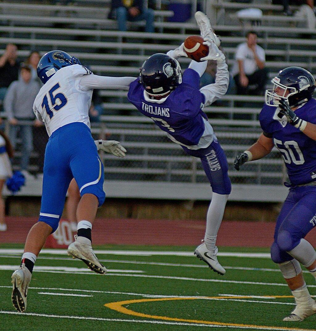 SUMNER FOWLER/FOR THE ARGUS-COURIERPetaluma's Jack Hartman makes a tumbling interception in front of Terra Linda receiver Anthony Moreno.