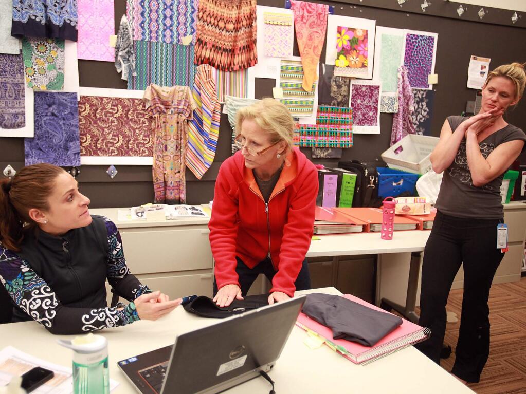 Athleta's Gretchen Harris, merchandiser, left, and Grace Altenau technical designer, center, discuss the fit of one of their pants being worn by Julie Alger, right, a fit model at Athleta headquarters in Petaluma, March 7, 2012.