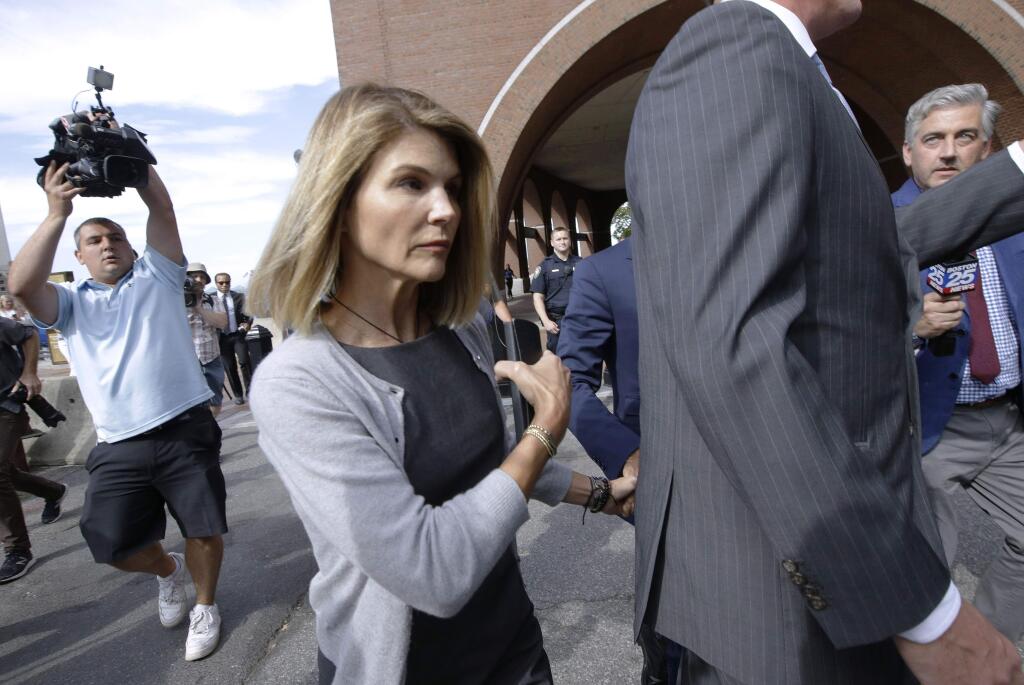 FILE - In this Aug. 27, 2019 file photo, actress Lori Loughlin departs federal court in Boston after a hearing in a nationwide college admissions bribery scandal. Loughlin, her fashion designer husband, Mossimo Giannulli, and nine other parents face new charges in the college admissions scandal. Federal prosecutors announced Tuesday, Oct. 22, 2019, that the parents were indicted on charges of conspiracy to commit federal program bribery. (AP Photo/Steven Senne, File)