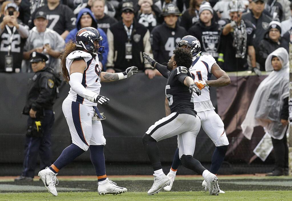 Oakland Raiders wide receiver Michael Crabtree, center, fights with Denver Broncos nose tackle Domata Peko, left, and cornerback Aqib Talib during the first half in Oakland, Sunday, Nov. 26, 2017. Crabtree and Talib were ejected. (AP Photo/Ben Margot)