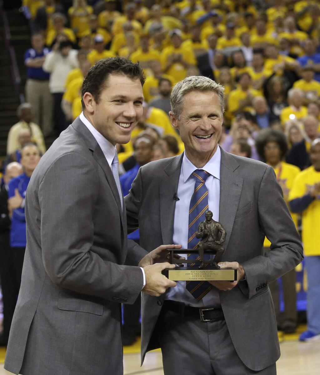 Golden State Warriors head coach Steve Kerr, right, poses for a photo with the league's coach of the year trophy alongside assistant coach Luke Walton before Game 5 of a first-round playoff series Wednesday, April 27, 2016, in Oakland. (AP Photo/Marcio Jose Sanchez)