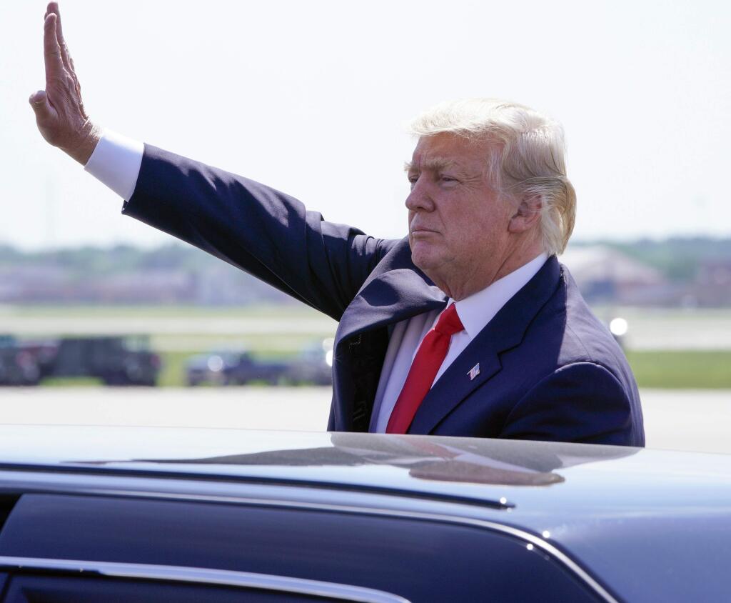 President Donald Trump waves from his car after speaking during a stop at General Mitchell International Airport Tuesday, June 13, 2017, in Milwaukee. (AP Photo/Morry Gash)
