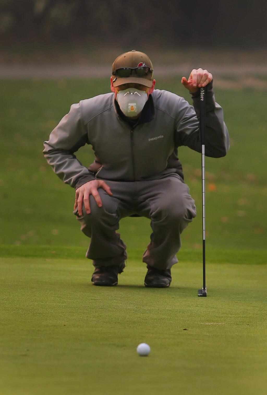 James McKenney, wearing a protective mask for the smoke, lines up his putt on the 9th hole of the Windsor Golf Club on Friday, Nov. 9, 2018. (CHRISTOPHER CHUNG/ PD)