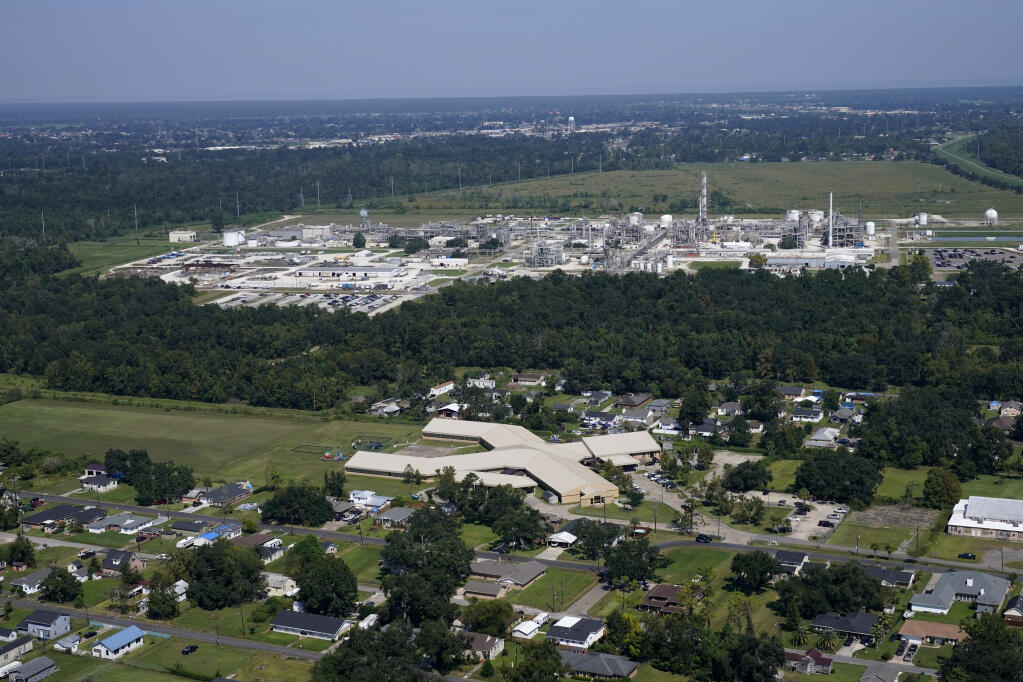 FILE - The Fifth Ward Elementary School and residential neighborhoods sit near the Denka Performance Elastomer Plant, back, in Reserve, La., Sept. 23, 2022. Federal officials are suing Louisiana chemical maker Denka Tuesday, Feb. 28, 2023, alleging that it presented an unacceptable cancer risk to the nearby majority-Black community and demanding cuts in toxic emissions. (AP Photo/Gerald Herbert, File)