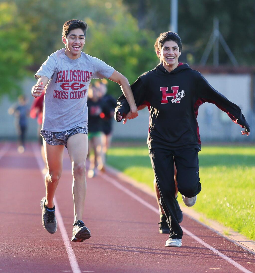 Healdsburg cross country runners Dante Godinez, left and Luis Quezadas goof around with each other as they warm up in Healdsburg on Thursday, November 17, 2016. (Christopher Chung / The Press Democrat)