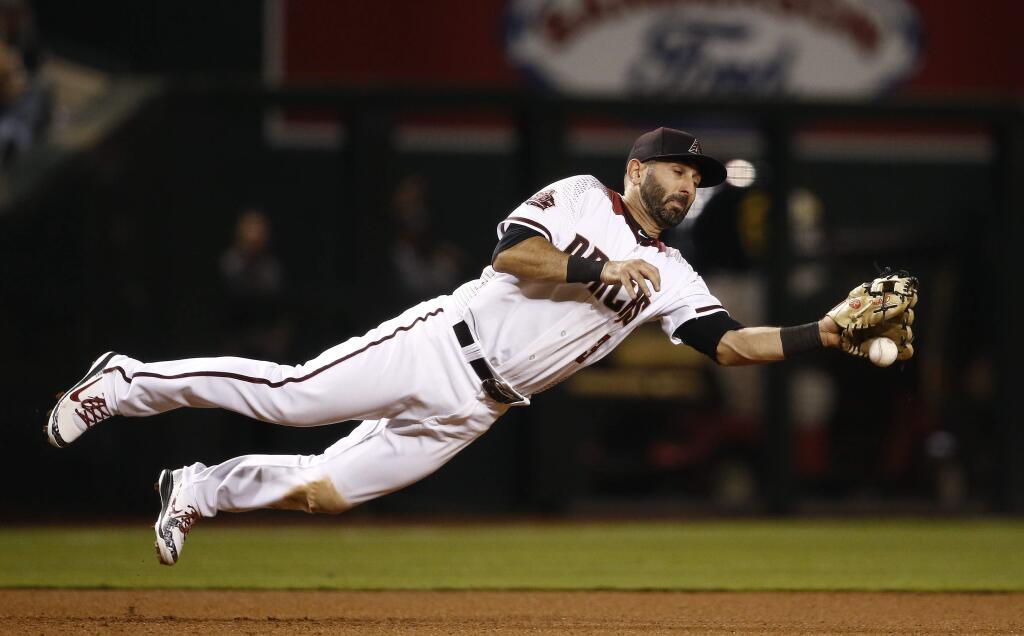 Arizona Diamondbacks third baseman Daniel Descalso knocks down a line drive hit by San Francisco Giants' Austin Jackson before throwing to second base to start a double play during the seventh inning of a baseball game Wednesday, April 18, 2018, in Phoenix. (AP Photo/Ross D. Franklin)
