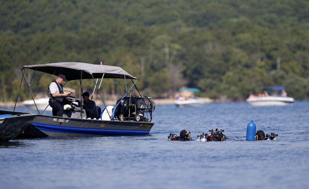 Divers from the Missouri State Highway Patrol enter the water at Table Rock Lake near Branson, Mo., on Monday, July 23, 2018 to begin salvage operations of a duck boat that sank, killing 17 people last week. (Nathan Papes /The Springfield News-Leader via AP)
