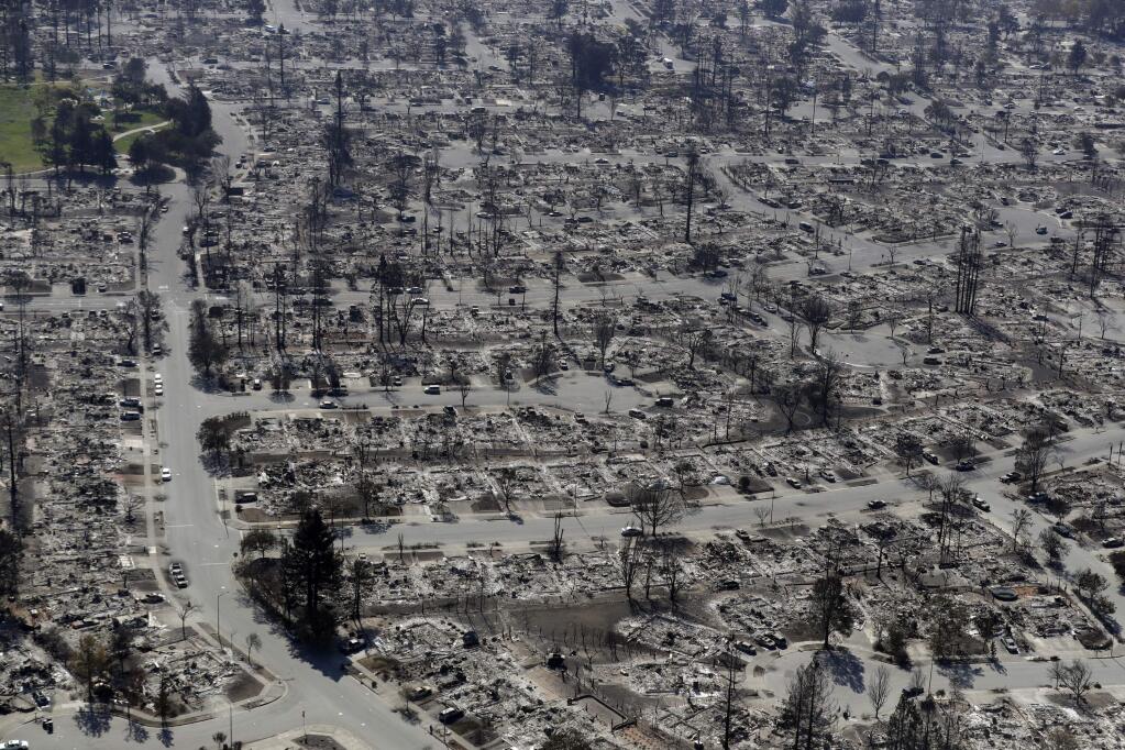 FILE - In this Oct. 14, 2017 file photo, an aerial view shows the devastation of the Coffey Park neighborhood after a wildfire swept through in Santa Rosa, Calif. California Gov. Jerry Brown has thrown his support behind limiting liability for electric utilities when their equipment causes wildfires. (AP Photo/Marcio Jose Sanchez, File)