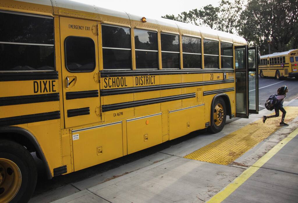 FILE - In this Oct. 18, 2018 file photo, a student hops off the school bus at Dixie Elementary School in San Rafael, Calif. The Dixie School District board in the California city of San Rafael plans to vote on whether to keep its name, which critics say it is linked to the Confederacy and slavery and supporters maintain is it named after a Native American woman. (Gabrielle Lurie/San Francisco Chronicle via AP, File)