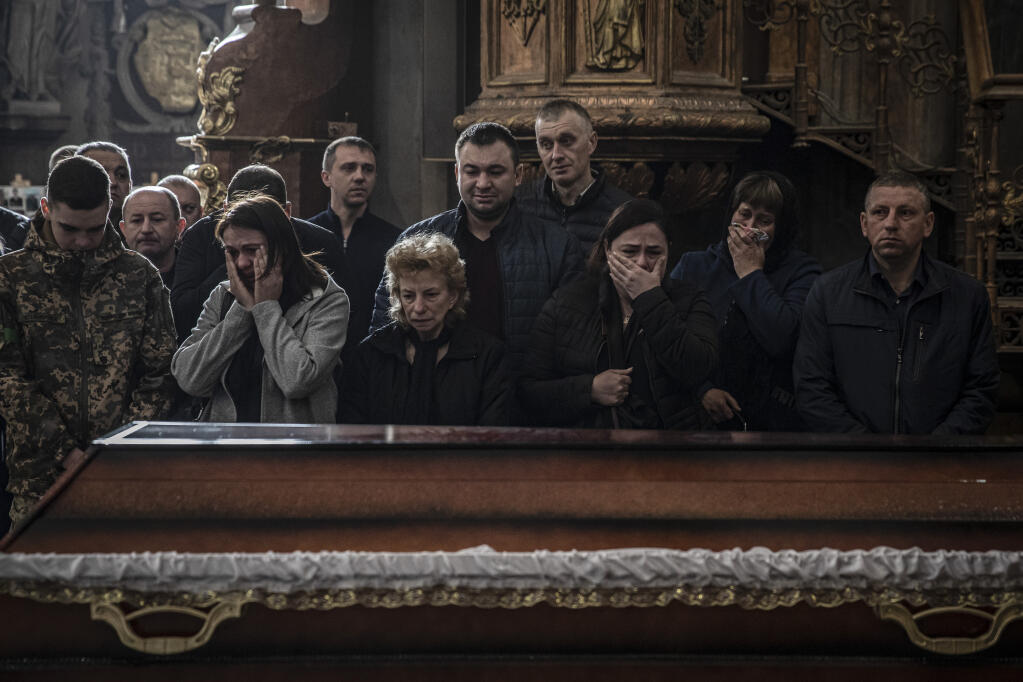 Mourners at the funeral of Liubomyr Tazaiev, who was killed by shrapnel while fighting in Popasna in the eastern Luhansk region, at the Saints Peter and Paul Garrison Church in Lviv, Ukraine, April 29, 2022. (Finbarr O’Reilly/The New York Times)