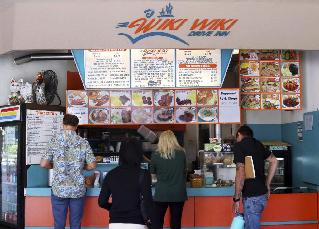 In this Thursday, March 14, 2019 photo, customers line up at the Wiki Wiki Drive Inn takeout restaurant counter in Honolulu. Hawaii would be the first state in the nation to ban most plastics used at restaurants, including polystyrene foam containers, if legislation lawmakers are considering is enacted. (AP Photo/Audrey McAvoy)